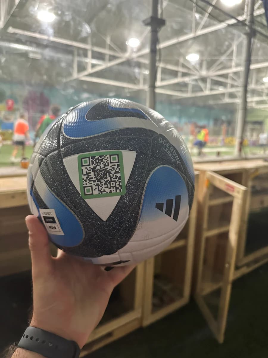 A blue soccer ball with a SoccQR tag fixed to a smooth ball panel